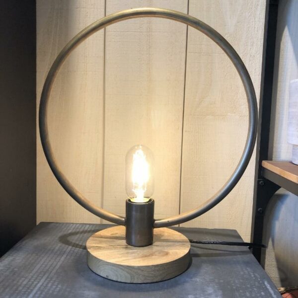 lampe à poser Tora en forme de cercle en metal patiné doré sur une base en bois